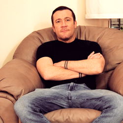 Man in a Tattooed Arm Sitting on Couch