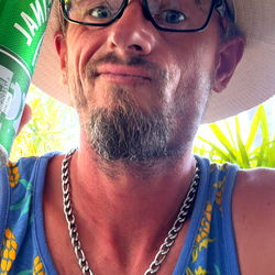 Man in Hawaiian Shirt and Hat holding Can