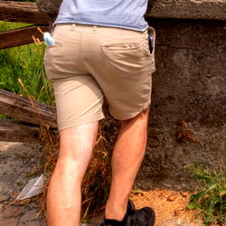 Model in Tan Shorts Leaning on Fence