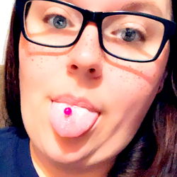 A playful snapshot of a young adult female with a tattooed tongue, celebrating the joy of individuality and confidence in her appearance.