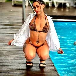 A woman posing in a bikini by the pool