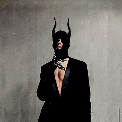 Model in a BDSM-inspired outfit, strong stance, captures attention