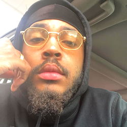 Master Sinn, a Rapper from Everywhere, in a Hoodie and Gold Chain.