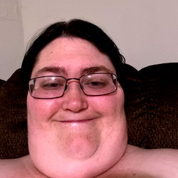 A heartwarming moment of a man with glasses and a beard smiling at the camera