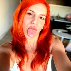 Vividly Red Hair Stands Out Against Backdrop, Model Makes Lips-Out Expression