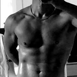 A Shirtless Photographer Taking a Mirror Selfie