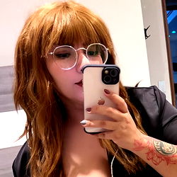 A woman taking a selfie in OnlyFans uniform