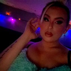 Model Ariella Mariee in a vibrant room, striking a pose and smiling at the camera