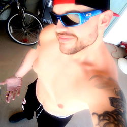 Shirtless Man with Tattoos and Earrings