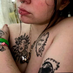 A tattooed individual with a relaxed posture