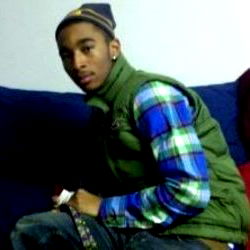 Adrick Sharpe, young male with hipster style in plaid shirt and beanie, sitting on couch
