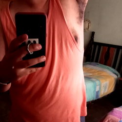 Model Alfy Van taking a mirror selfie in a room