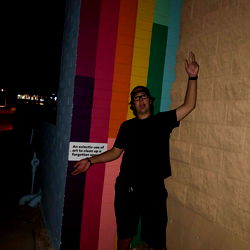 Standing against a colorful backdrop at night
