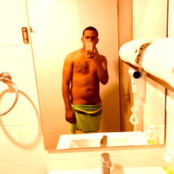 A Shirtless Man in a Bathroom Mirror