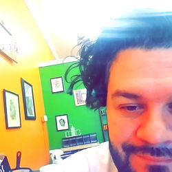 A person in a room, leaning on an arm