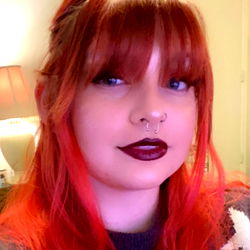 Stylish Red-Haired Woman with Dark Lipstick and Piercing