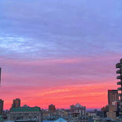 Stunning Sunset over a City Skyline with Distant Buildings and Trees