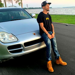 Ant Low Stands Confidently in Jacksonville, Florida with His Silver Car