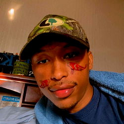 Avery, a young man in camouflage hat and beard, captured a moment of relaxation at home.