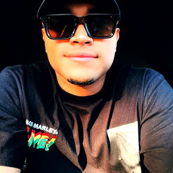 Alexander in a casual pose with a baseball cap and sunglasses