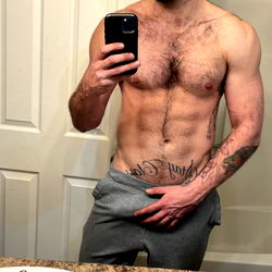 A Fit and Tattooed Man Showing Off His Muscular Body