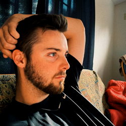Relaxed Young Man Resting Head on Hand in Casual Setting
