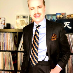 Casually Dressed Man in Suit with Mustache Sticker on Shirt