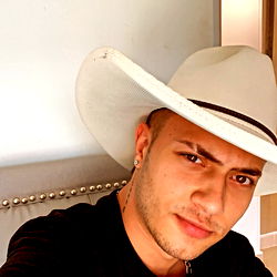 Silenciobruno in a cowboy hat, posing for selfie
