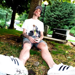 A Young Man Resting on the Grass in an Urban Park