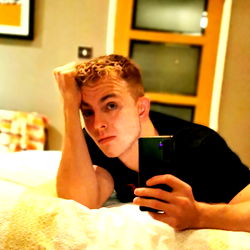 Young Man Taking a Selfie in Bed