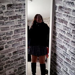 Stylish Model Standing in Brick-Walled Room