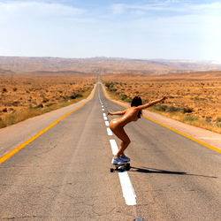 Daring Daughter of Israel Riding Skateboard on Paved Road